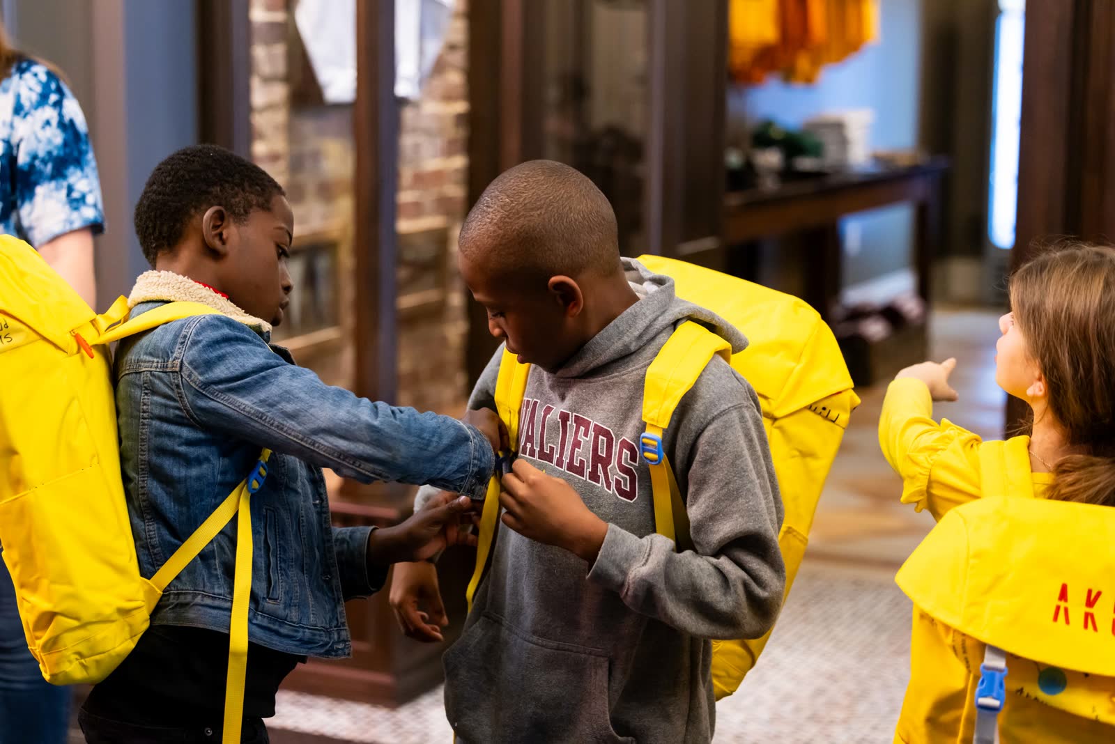 Kids holding the yellow Aku backpack